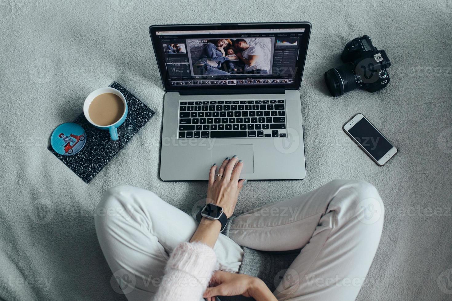 Woman using laptop on her bed photo