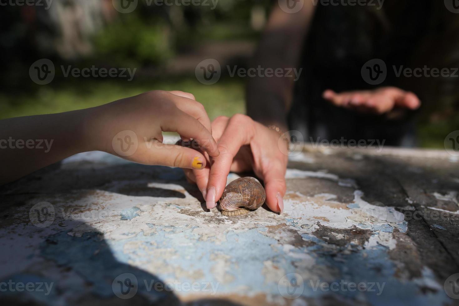 girl with a snail in the garden photo