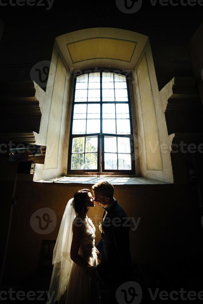 bride and groom on the background of a window. photo