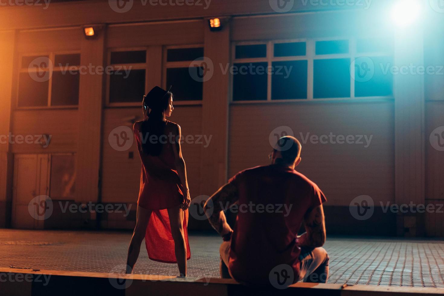 A young sexy couple lovers pose on the night street of the city. photo
