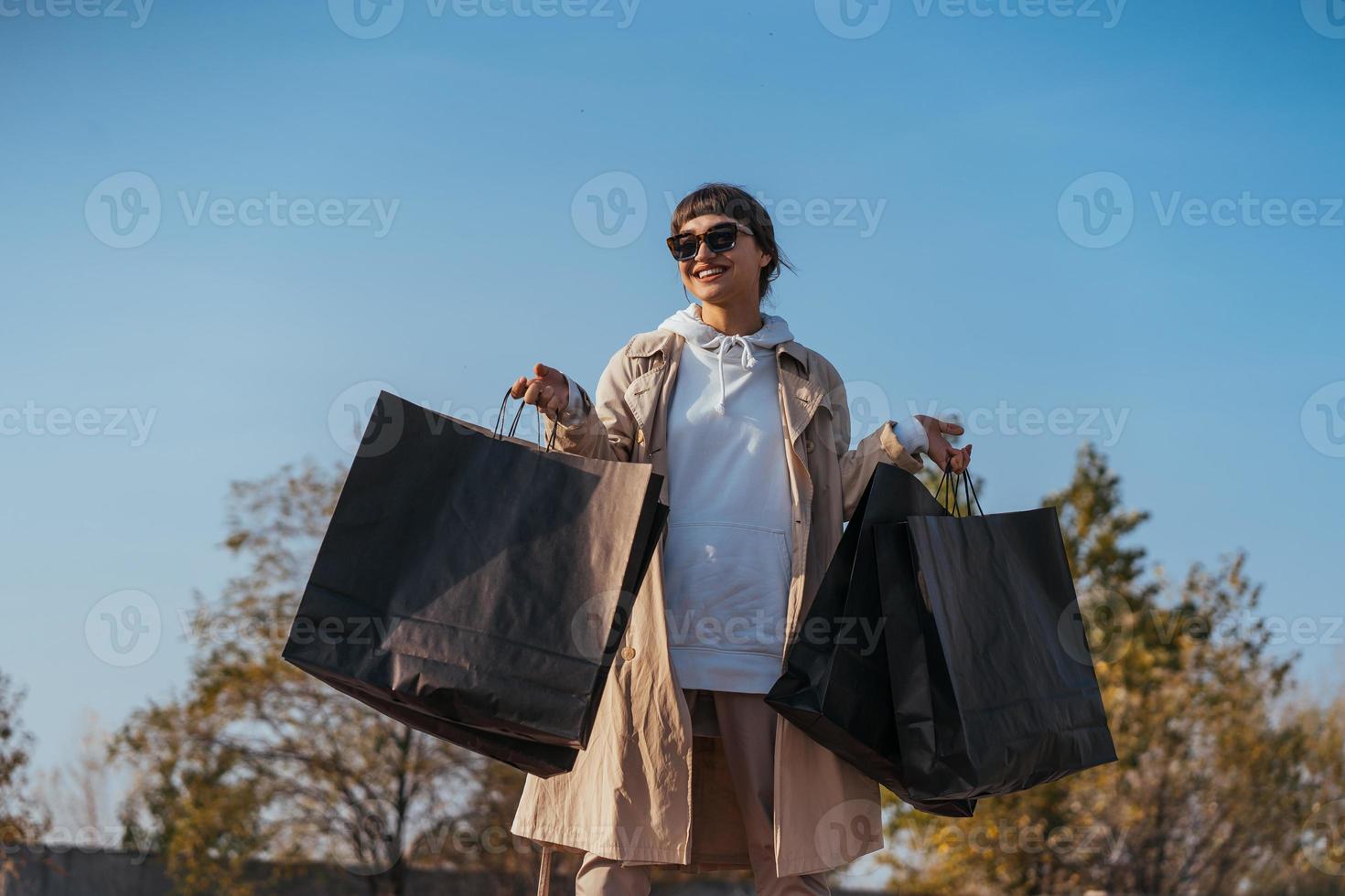 A young woman is standing in a car with bags in her hands photo