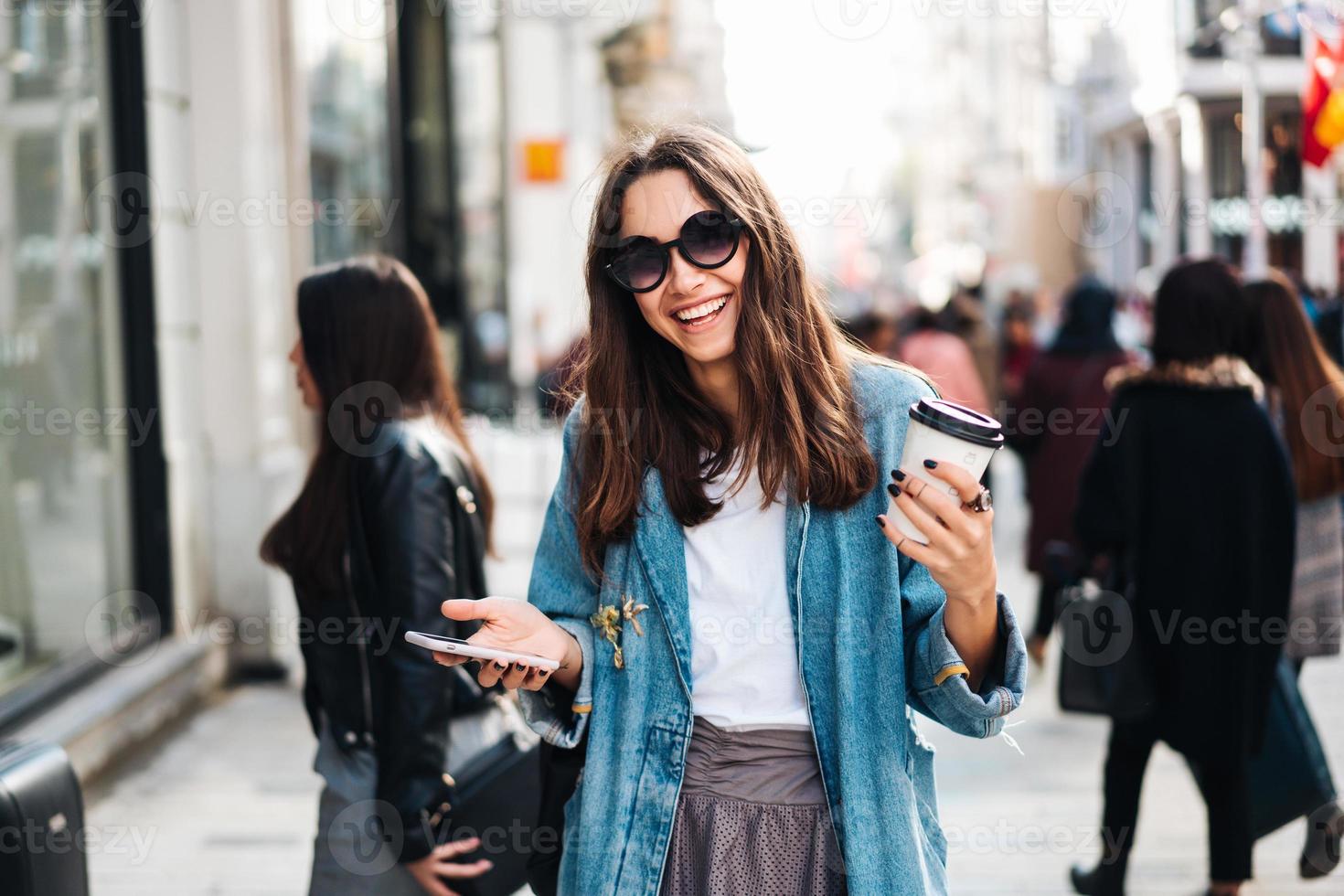 bella mujer sonriente caminando por las calles de la ciudad foto