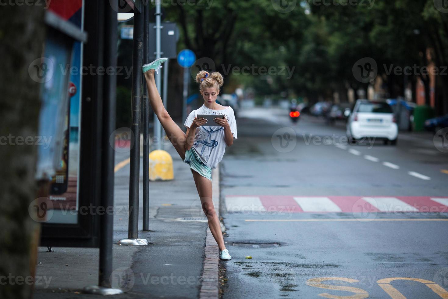 Cute girls with tablet on a bus station with a leg split photo