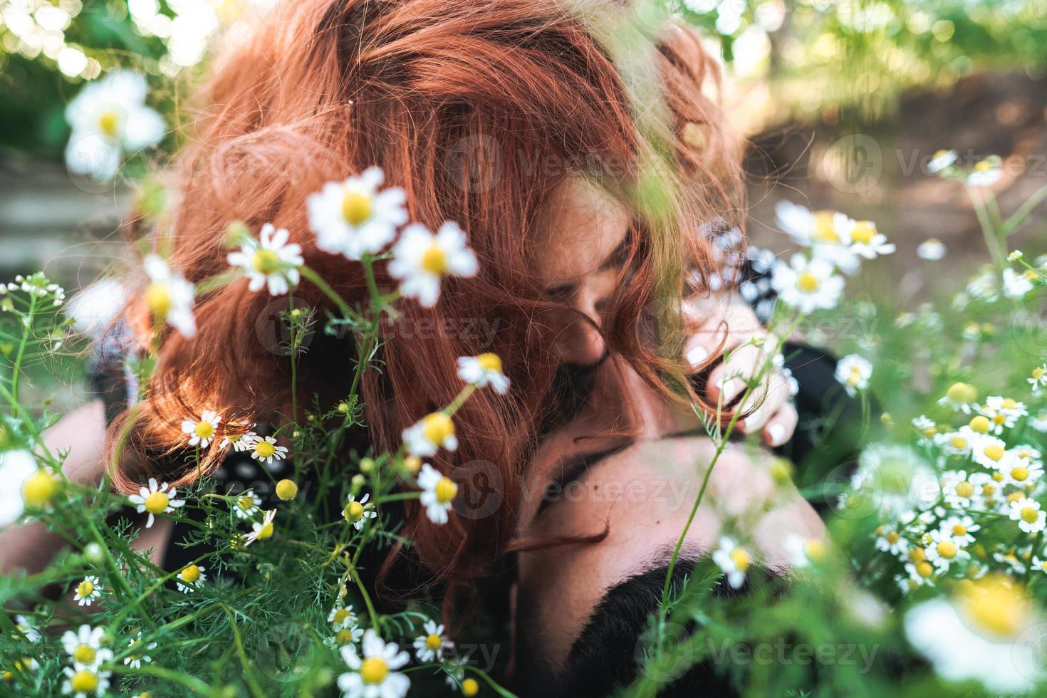 Young couple lies on the field with daisies. photo