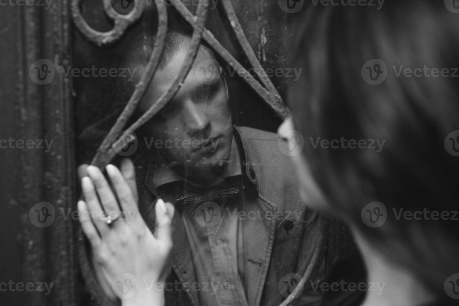 European young couple looking at each other through the window photo