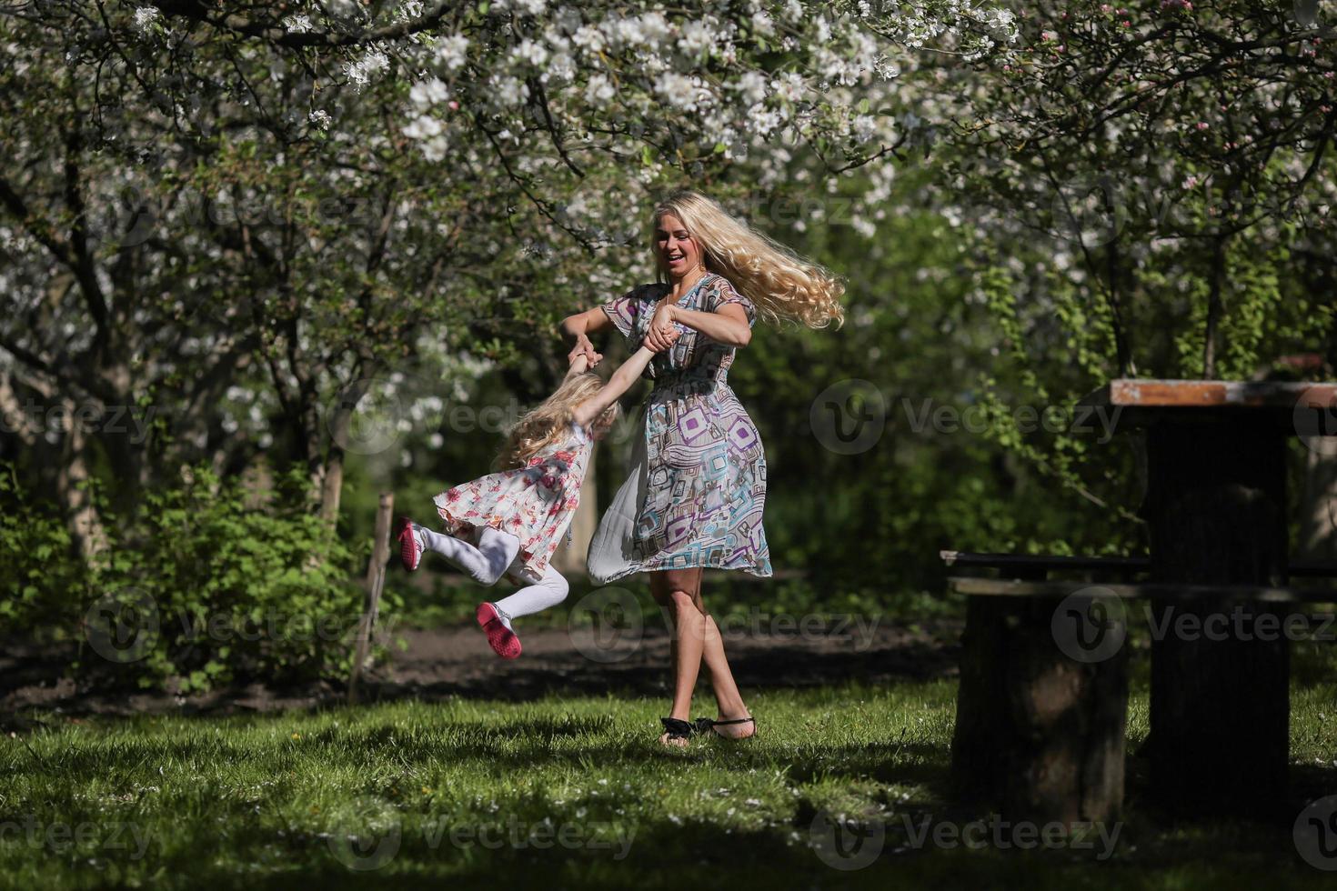 mother twist daughter in the garden photo