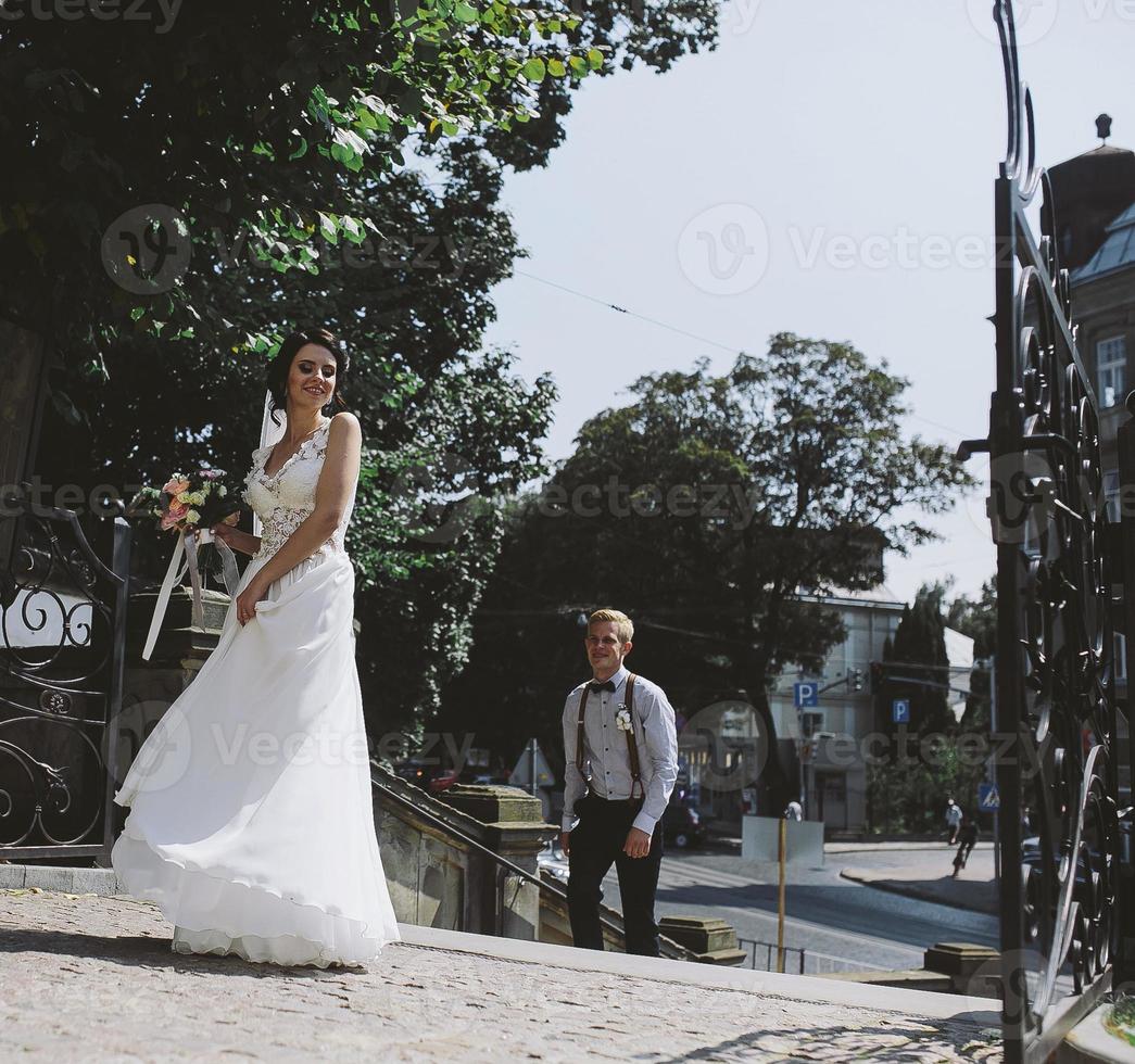 bride and groom posing on the streets photo