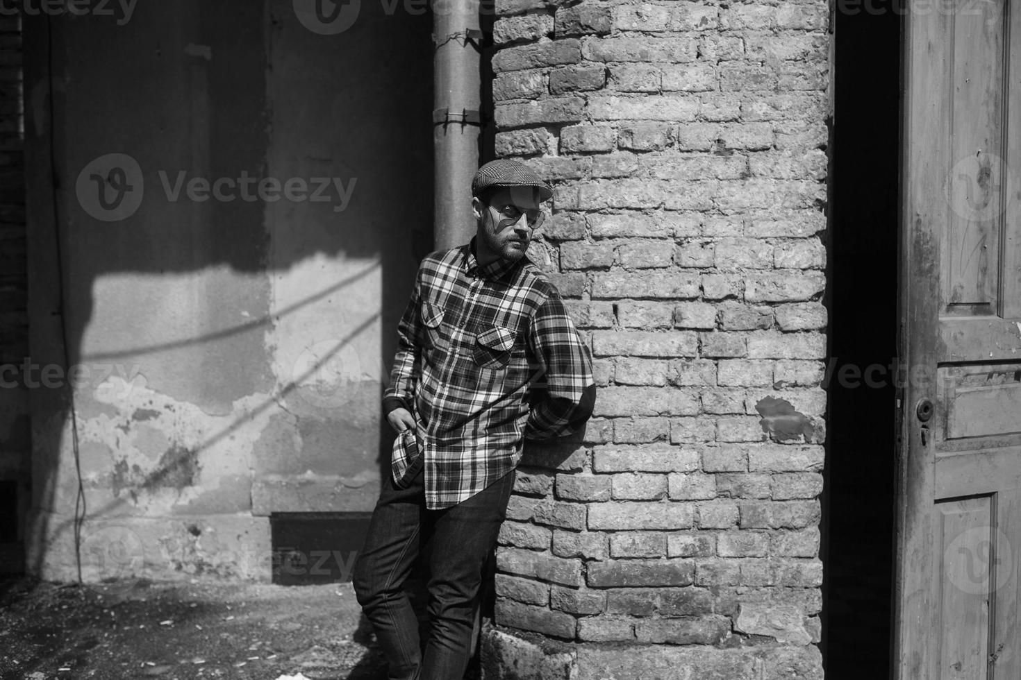 The man in the authentic boots and selvedge jeans  on a background of old city photo