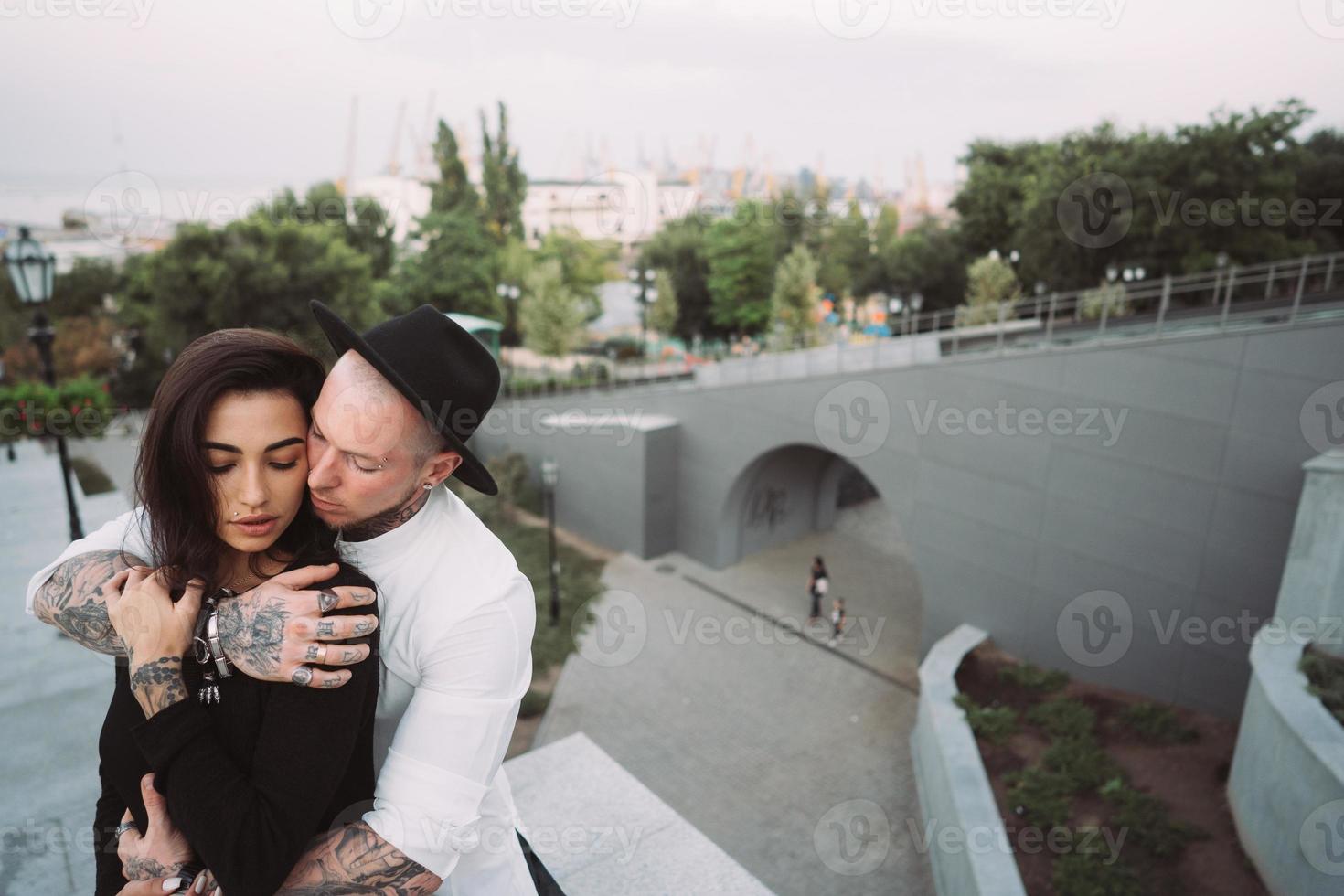 A young, sexy couple of lovers pose for a camera on the streets photo