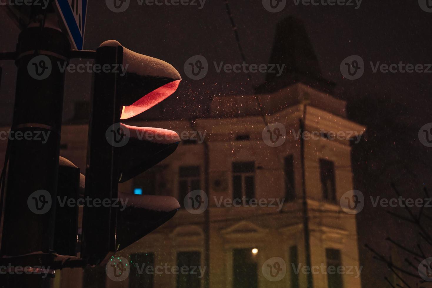 Traffic light on a snowy night photo