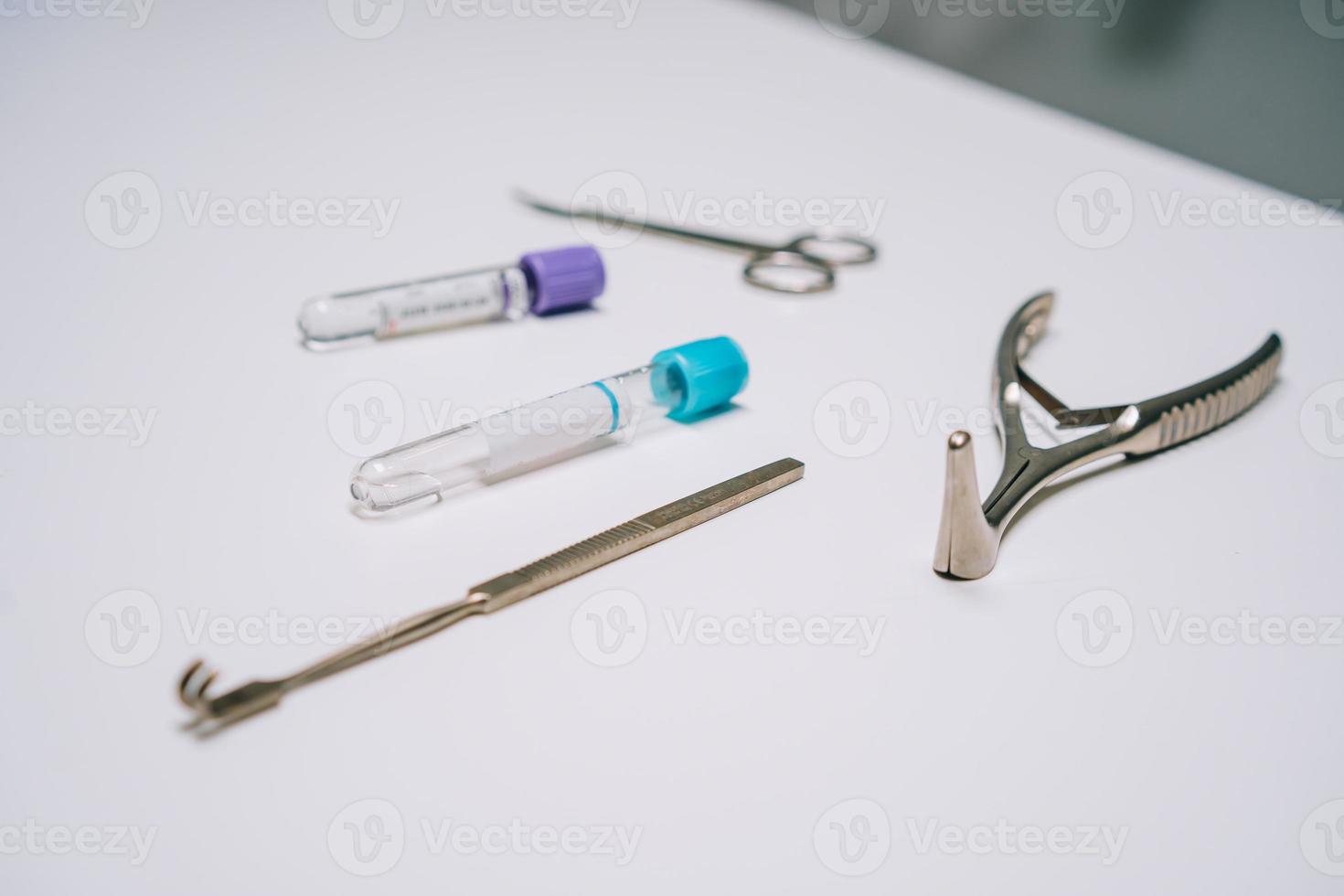 surgical instruments and several test tubes lie on the table photo