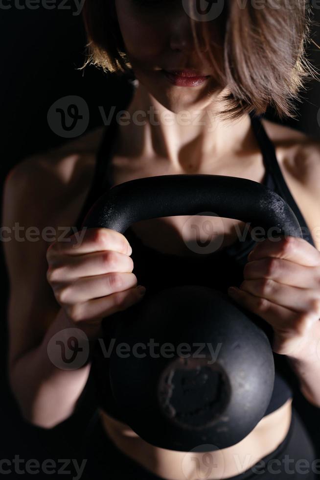 joven deportista haciendo ejercicios con pesas rusas foto