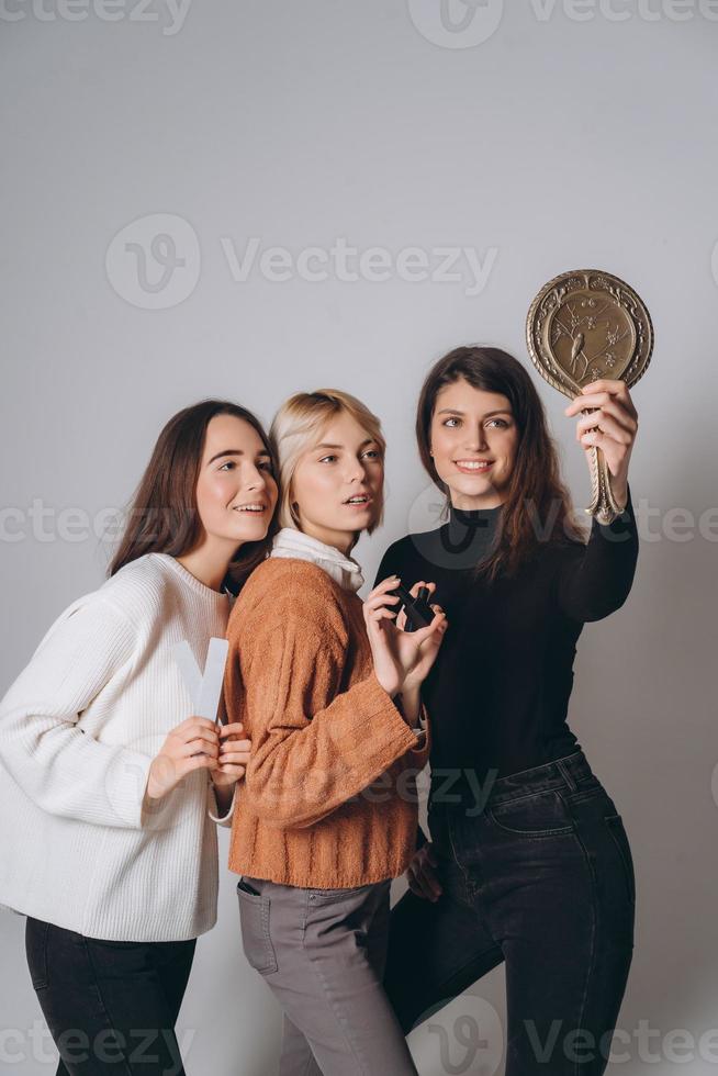 Three beautiful young girls posing for the camera photo