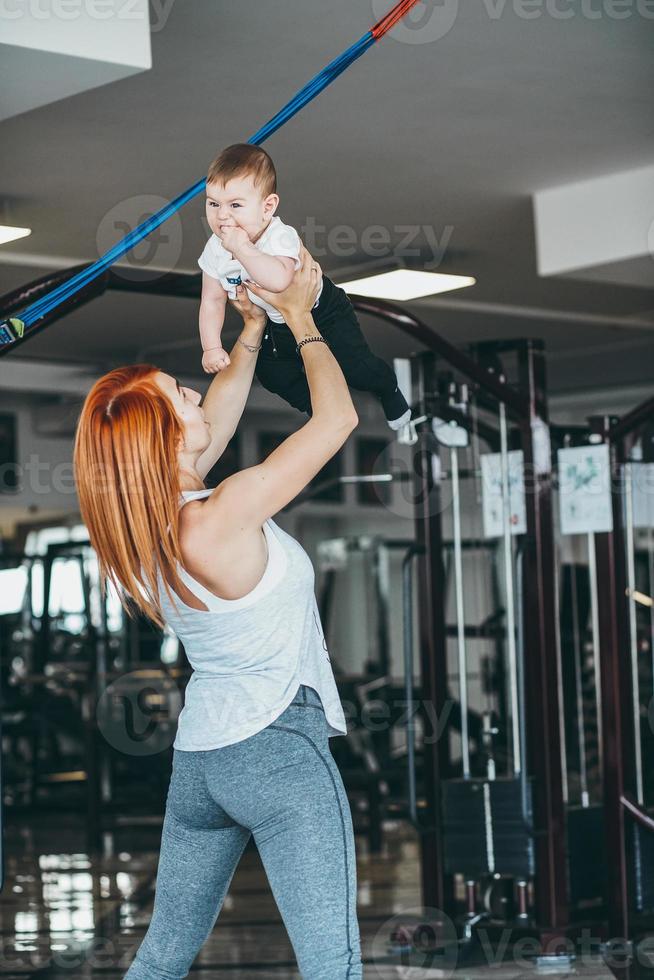 joven madre con su hijo pequeño en el gimnasio foto