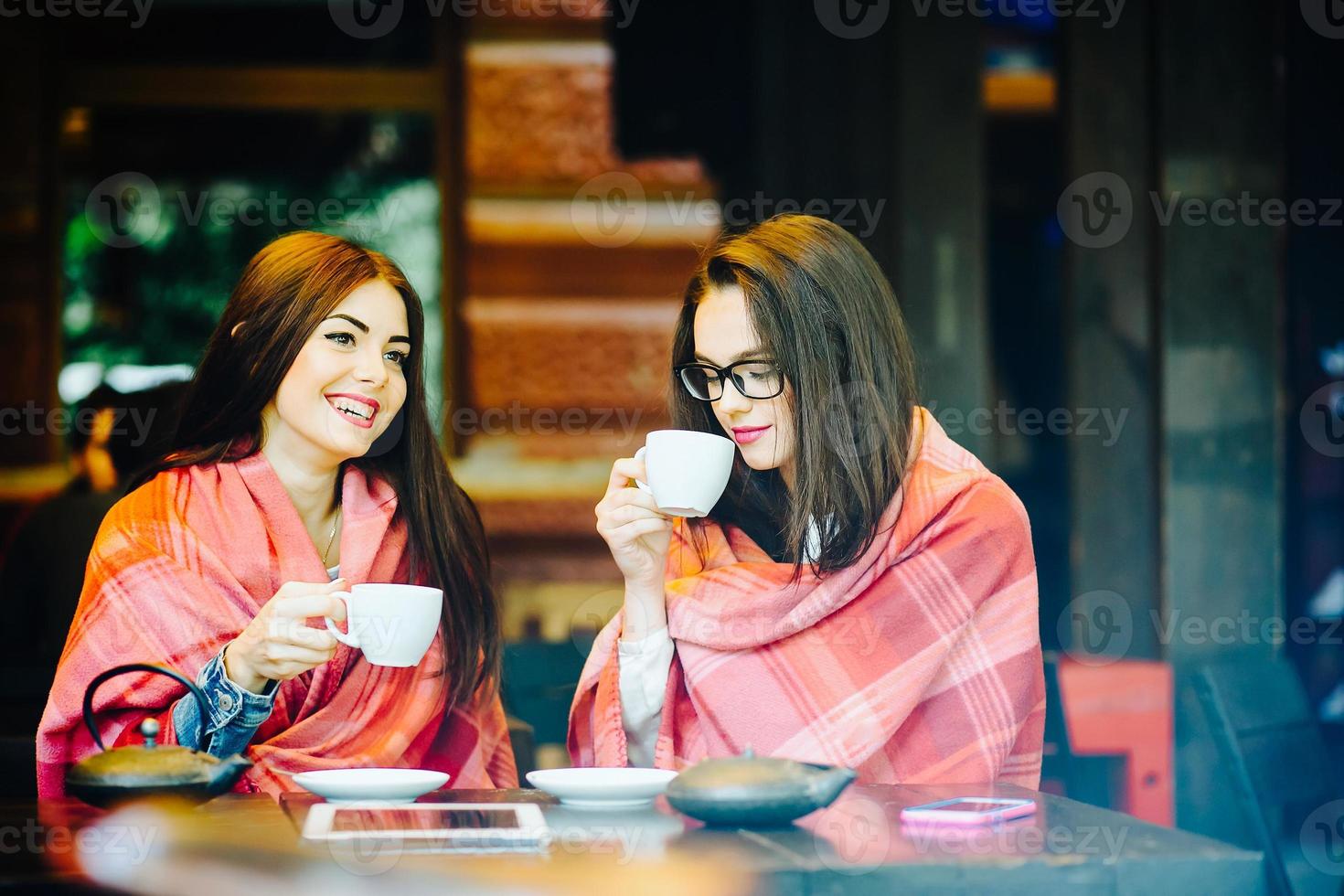 Two young and beautiful girls gossiping photo