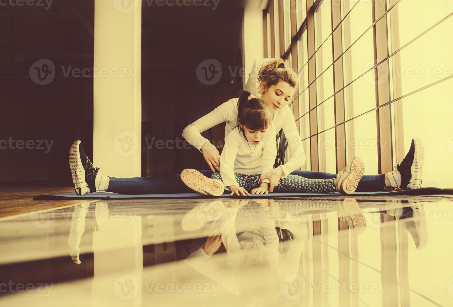 Mother and daughter hugs and stretch in the gym photo