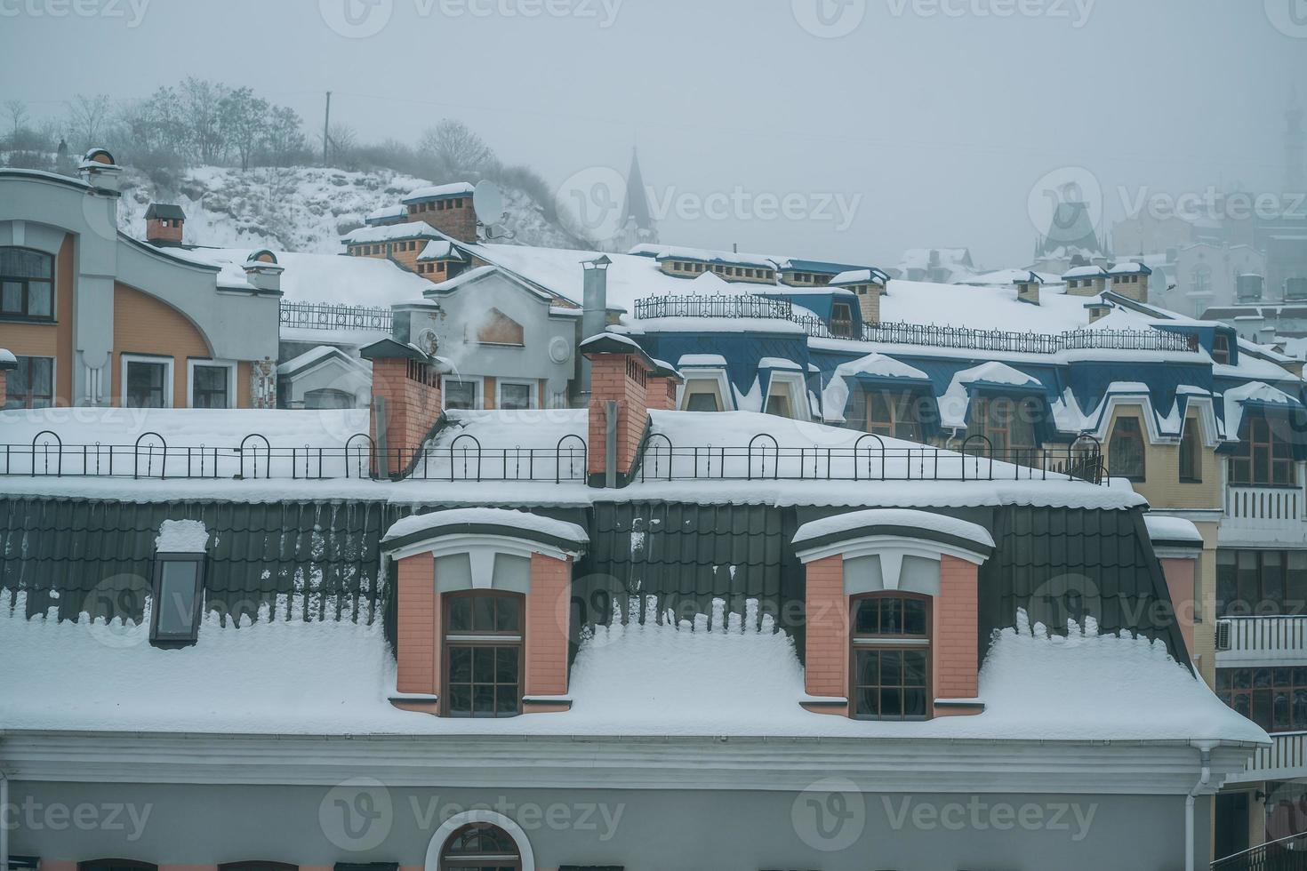 Copious snowfall over the city with the roofs photo