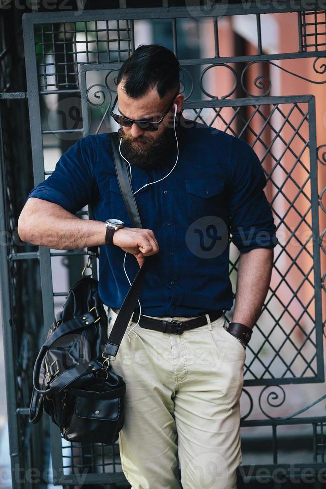 bearded man standing and listening to music photo