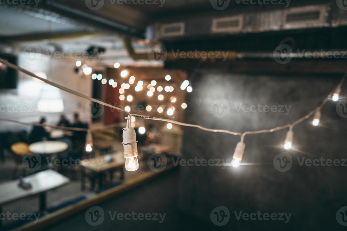 Lamp on garland with lights on background photo