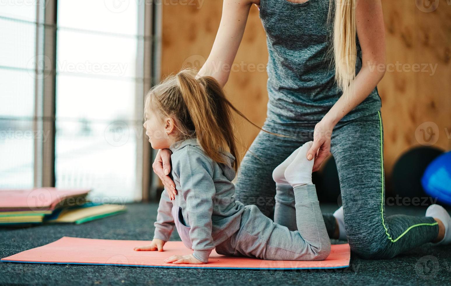 A little girl repeats exercises for her mother photo