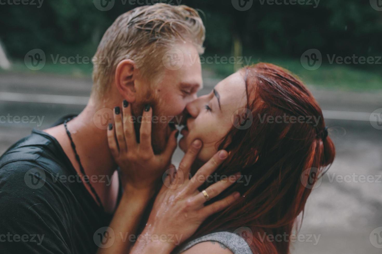 hermosa pareja besándose bajo la lluvia foto