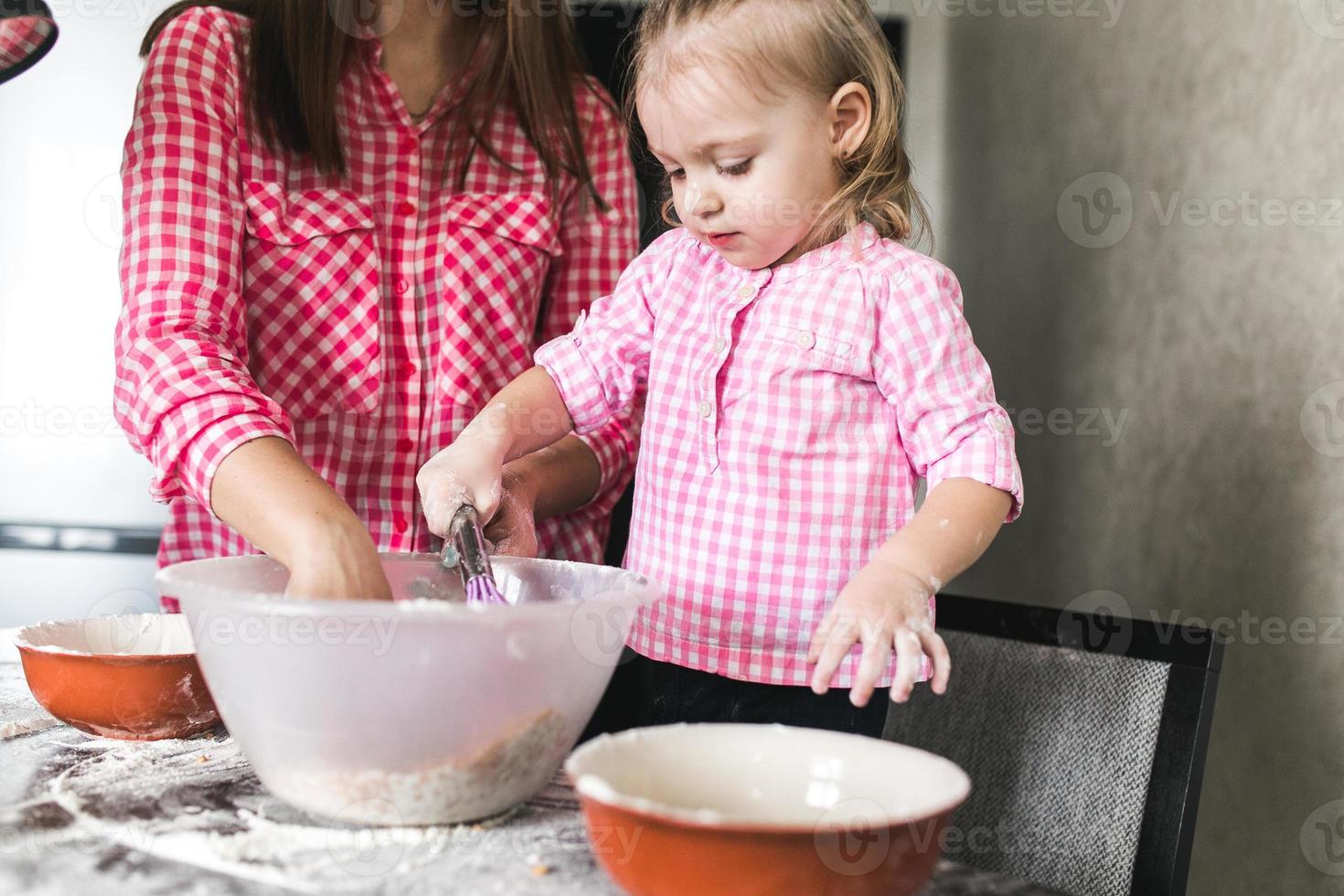 mamá e hija juntas en la cocina foto