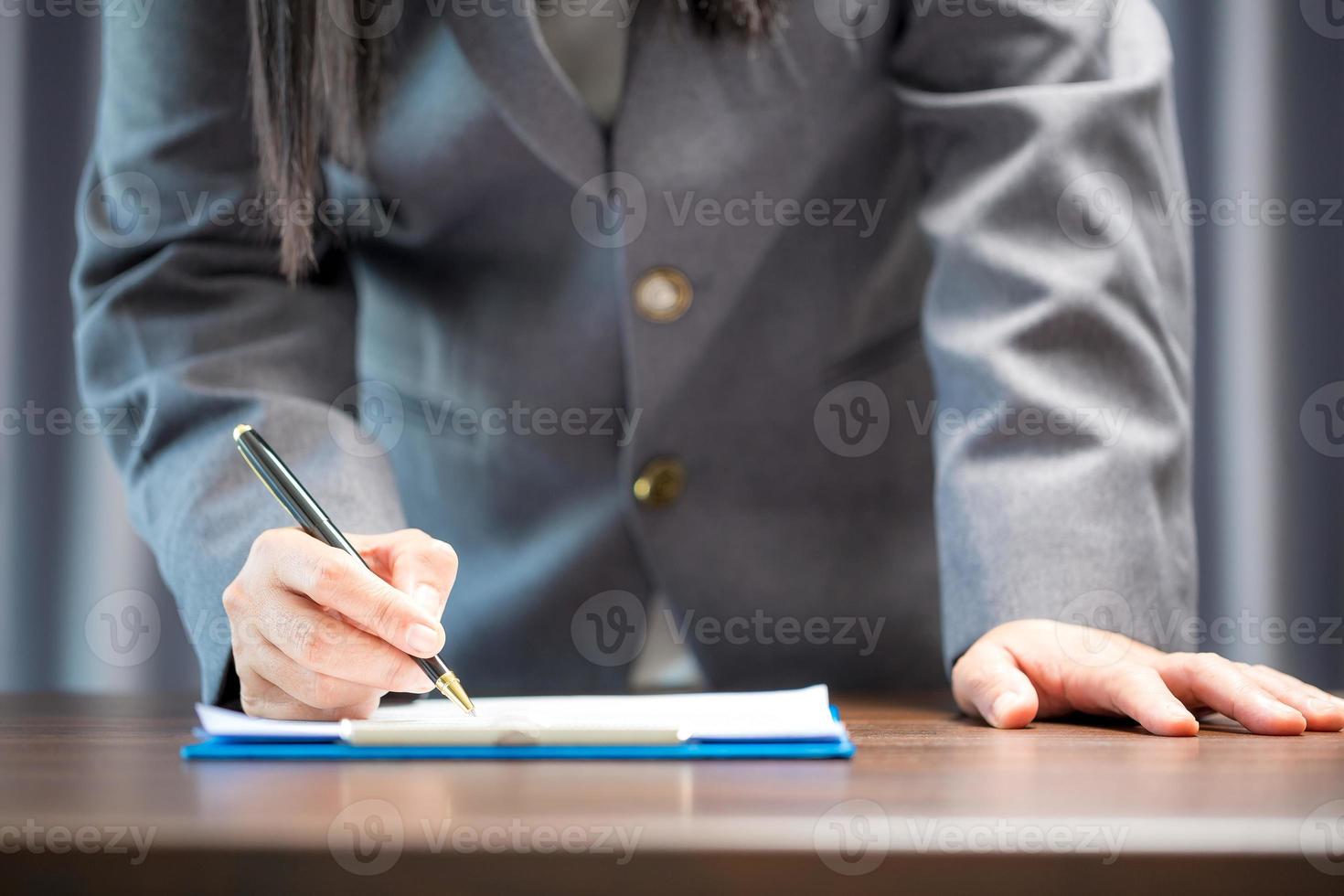 Workplace closeup person professional businesswoman sitting at desk hold pen signing or