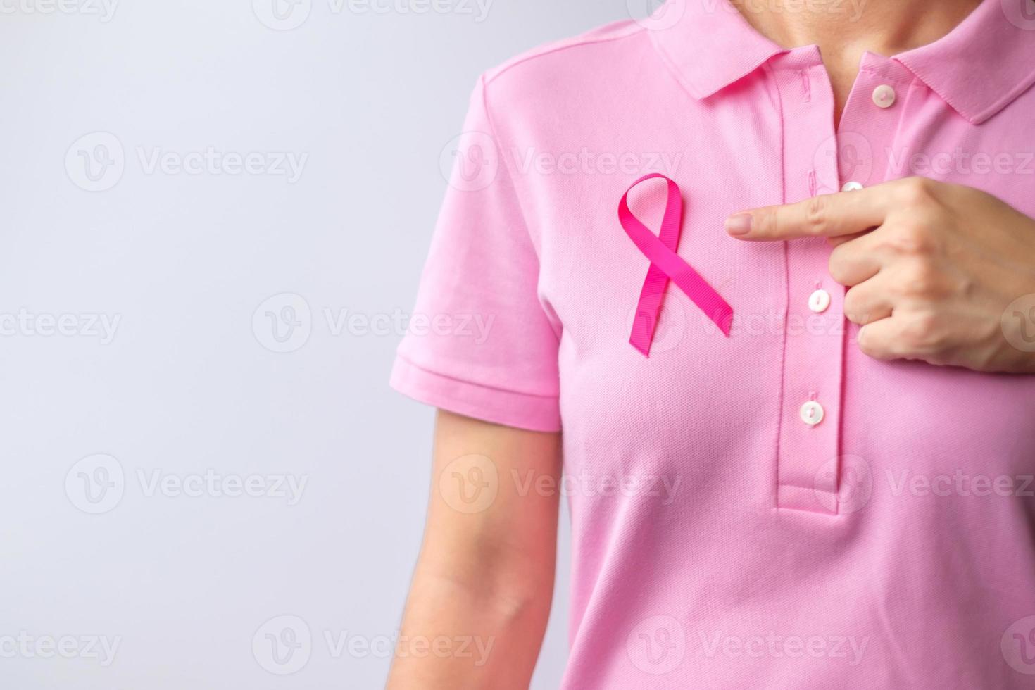 mes de concientización sobre el cáncer de mama de octubre rosa, la mano de la mujer sostiene una cinta rosa y usa una camisa para apoyar la vida y la enfermedad de las personas. concepto del mes nacional de los sobrevivientes del cáncer, la madre y el día mundial del cáncer foto