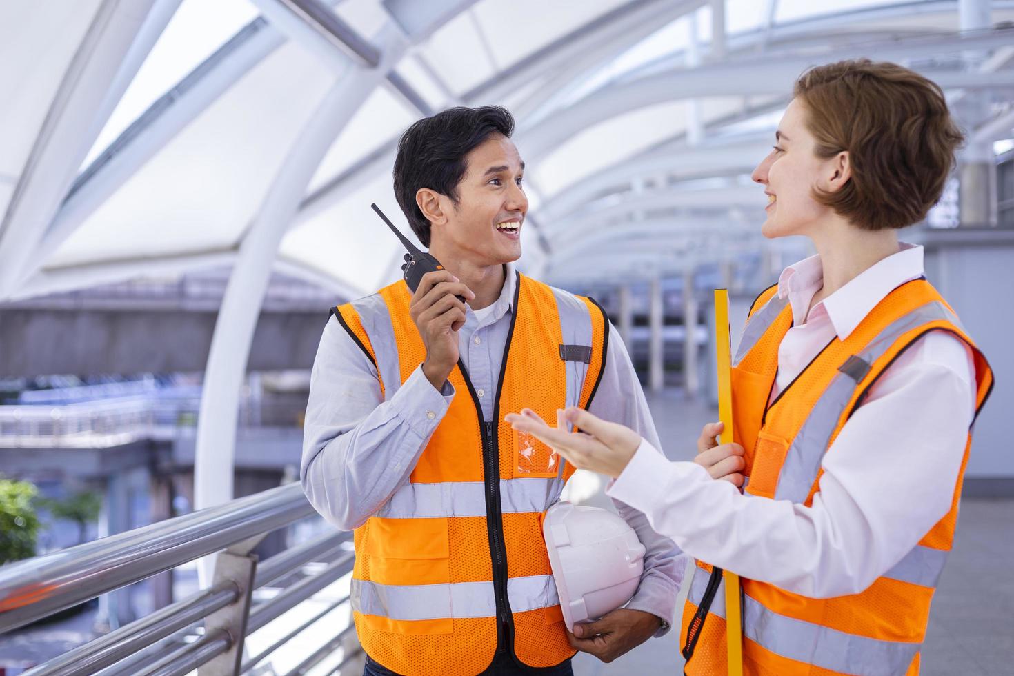 el equipo de ingenieros de diversidad está usando walkie talkie mientras inspecciona el proyecto de construcción para la arquitectura moderna y el concepto de desarrollo inmobiliario foto