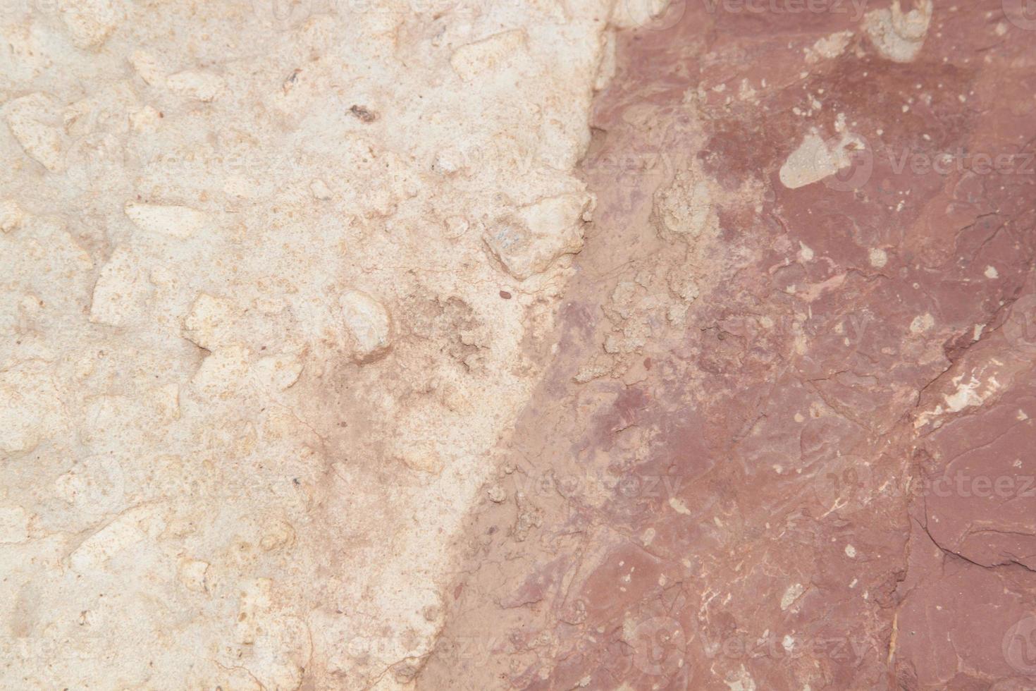 Textures of red sandstone and concrete - created by skilled craftsmen in a riverside garden with large tawny stones in an effort to absorb currents and water surfaces. photo