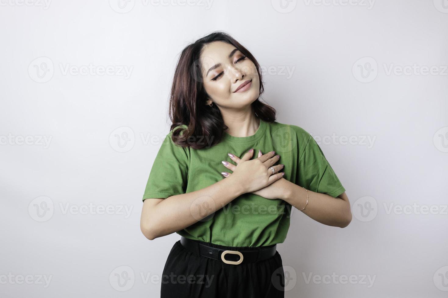 Happy mindful thankful young woman hand on chest smiling isolated on white background photo