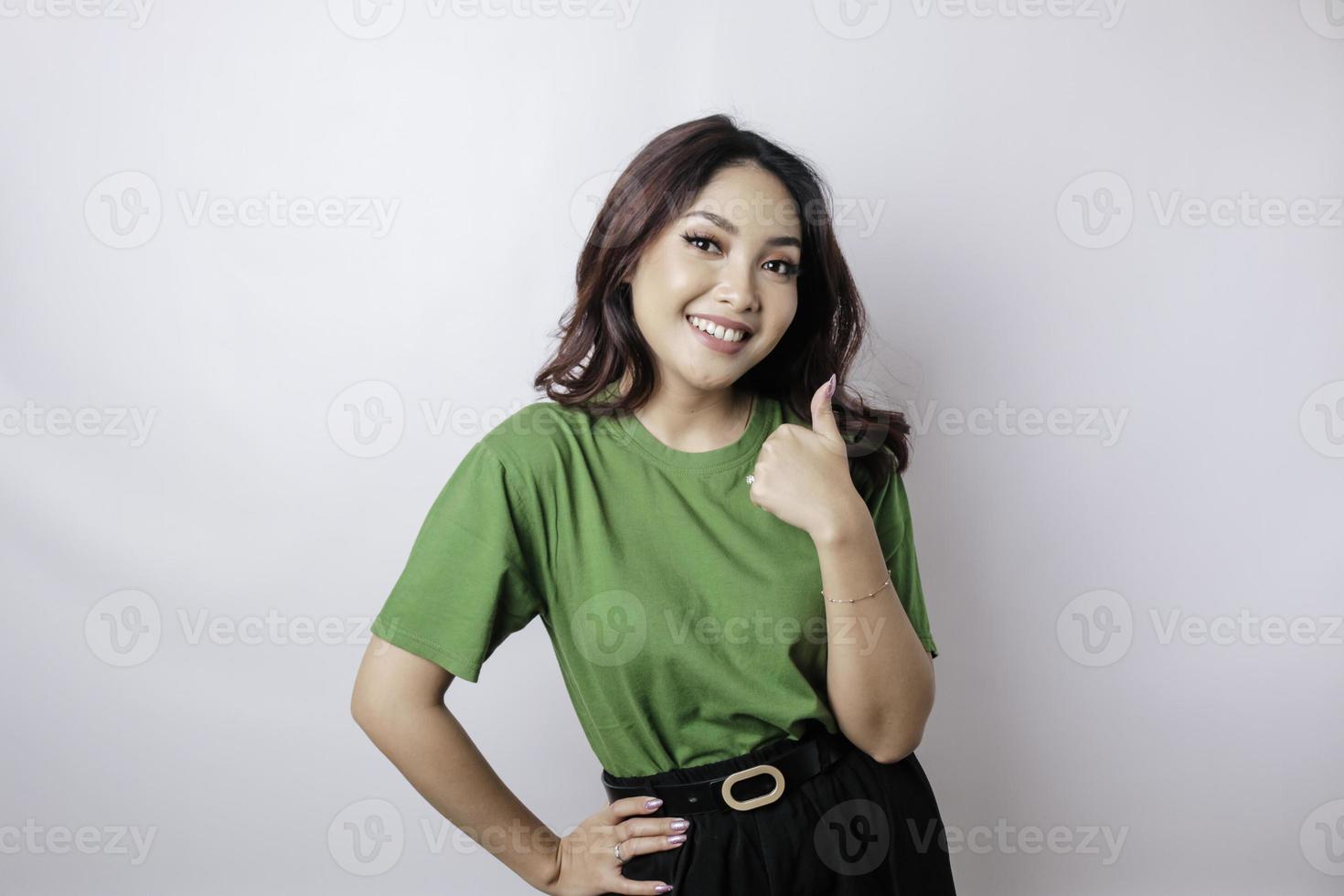 Excited Asian woman gives thumbs up hand gesture of approval, isolated by white background photo