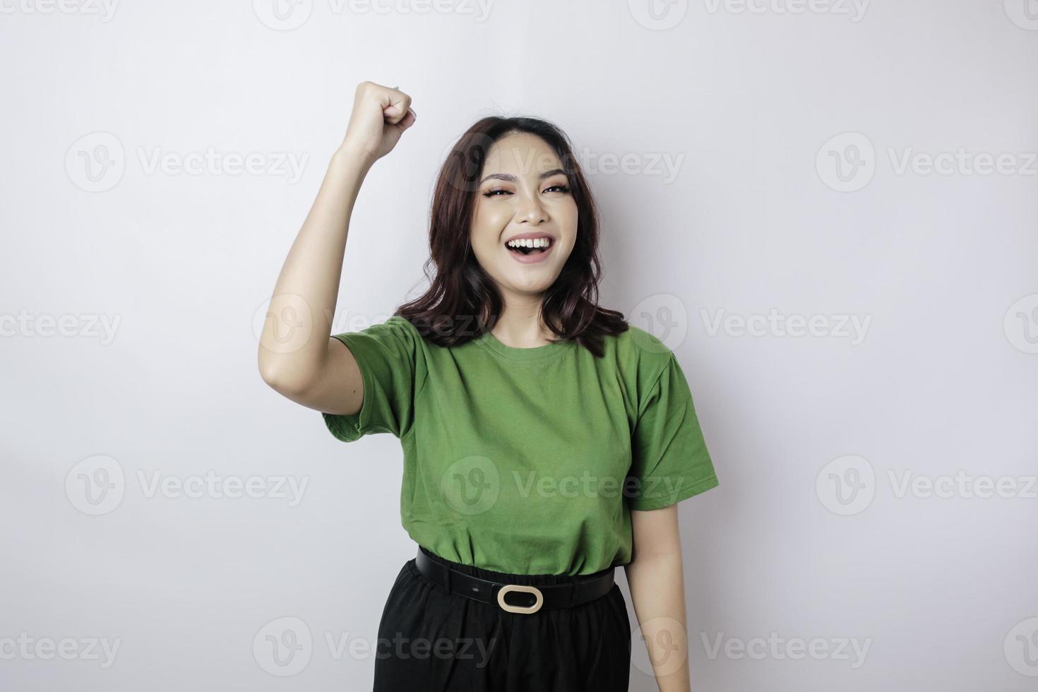 A young Asian woman with a happy successful expression wearing green shirt isolated by white background photo