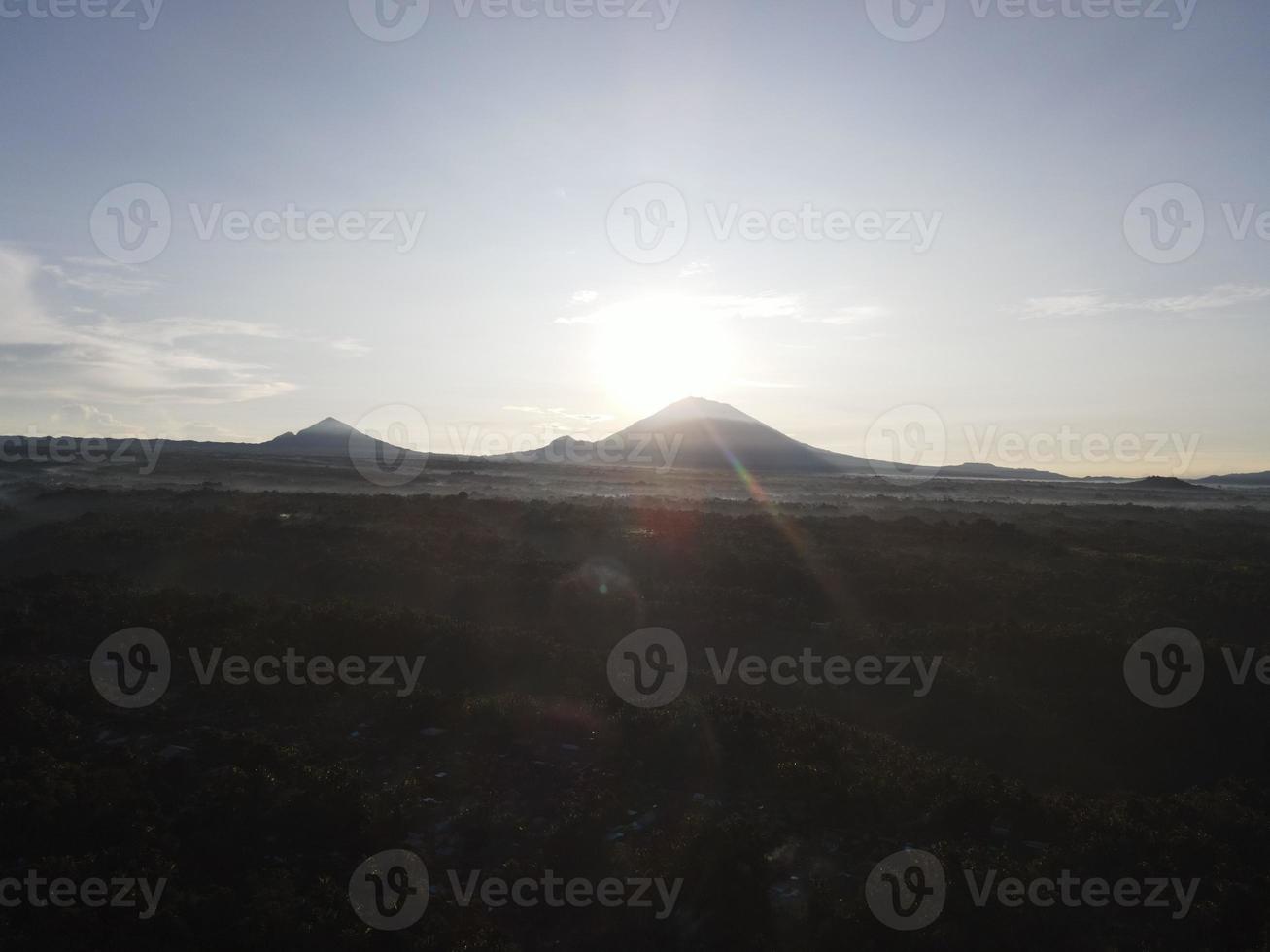 Sunrise over hillside with long sun rays pass through valley in village Bali, Indonesia photo