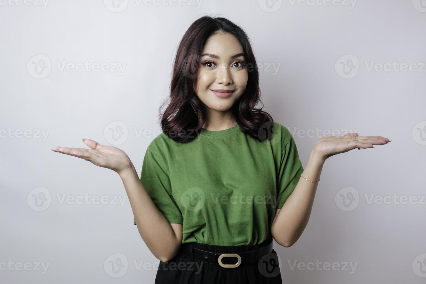 Smiling beautiful Asian woman pointing finger sideward to empty space isolated white background photo