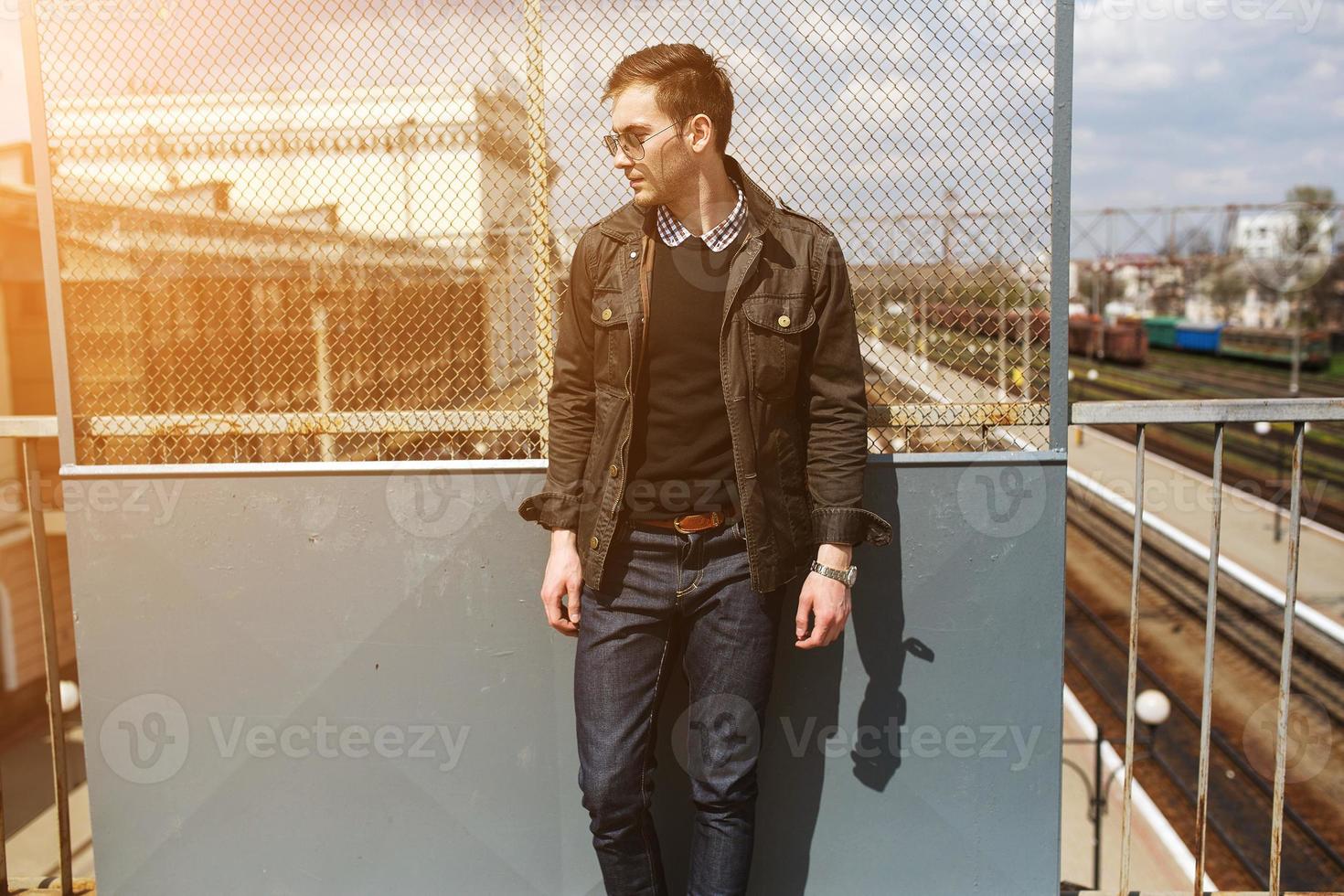 A man dressed in jeans on the background of the train and the station photo