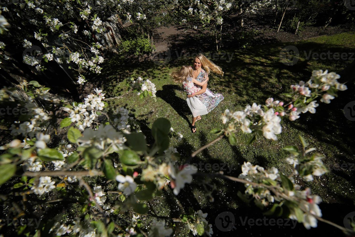 mother twist daughter in the garden photo