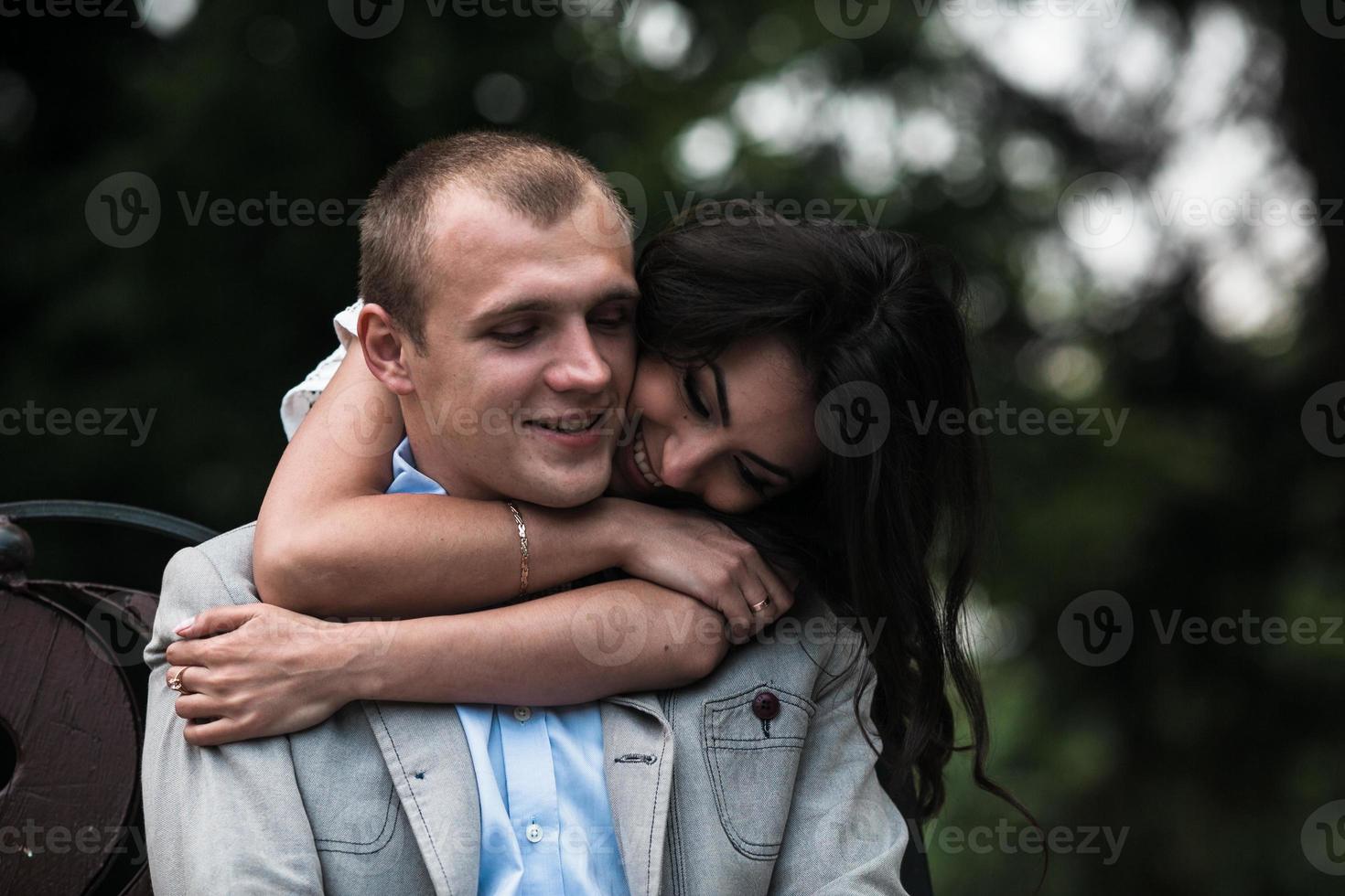Young European couple cuddling on a park bench photo