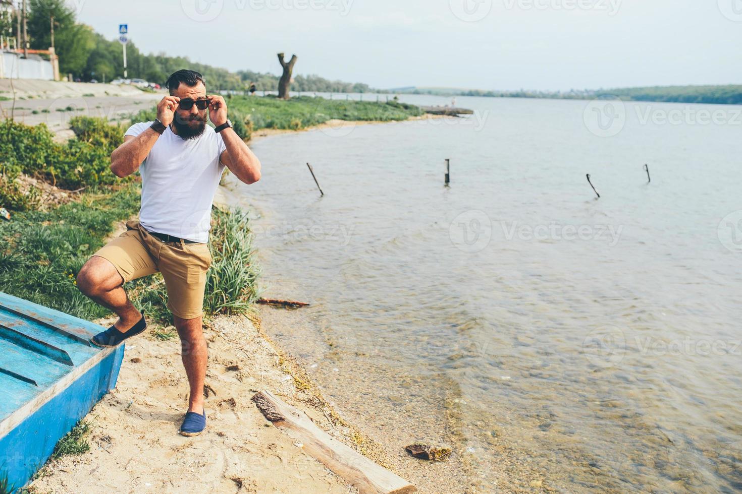 hombre barbudo americano mira a la orilla del río foto