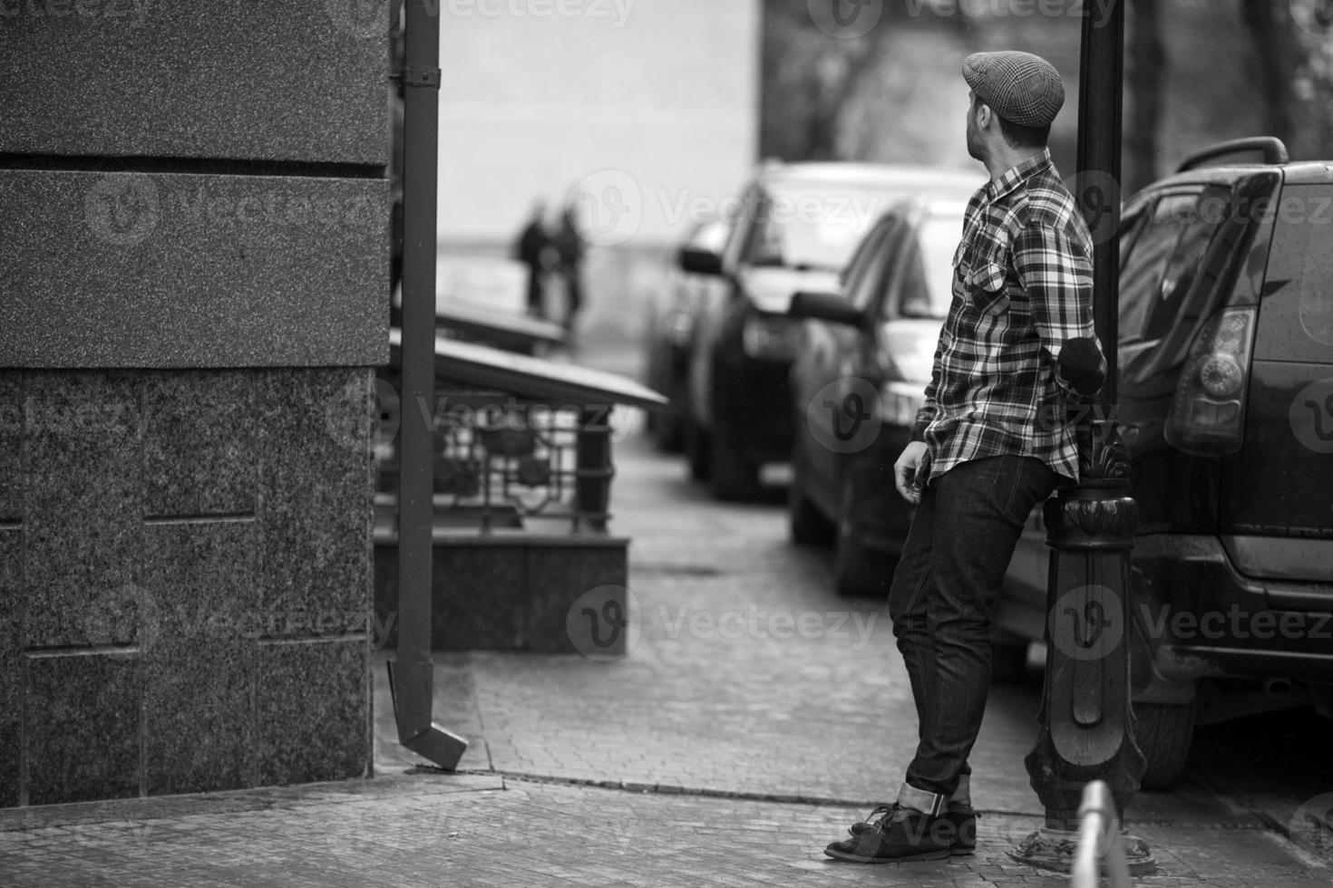 El hombre de las botas auténticas y jeans de orillo sobre un fondo de ciudad vieja foto