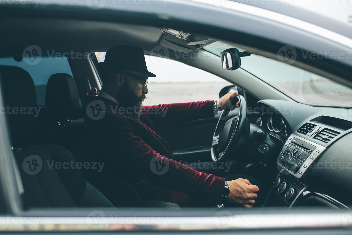 Man with beard driving a car photo