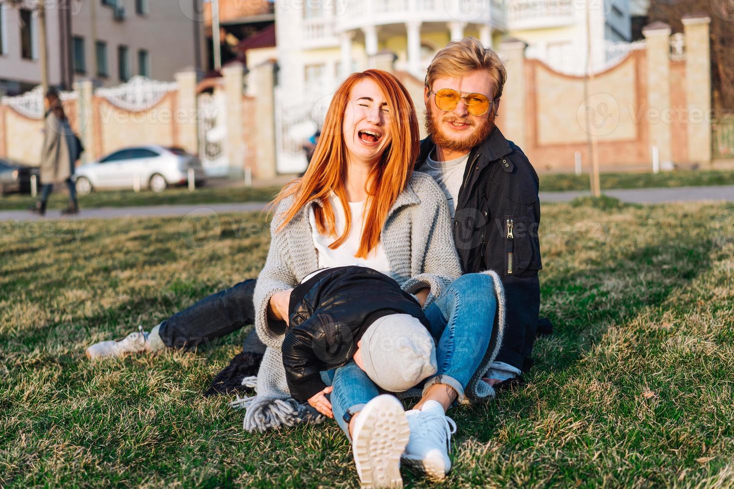 happy mom dad and son hugging in the park photo