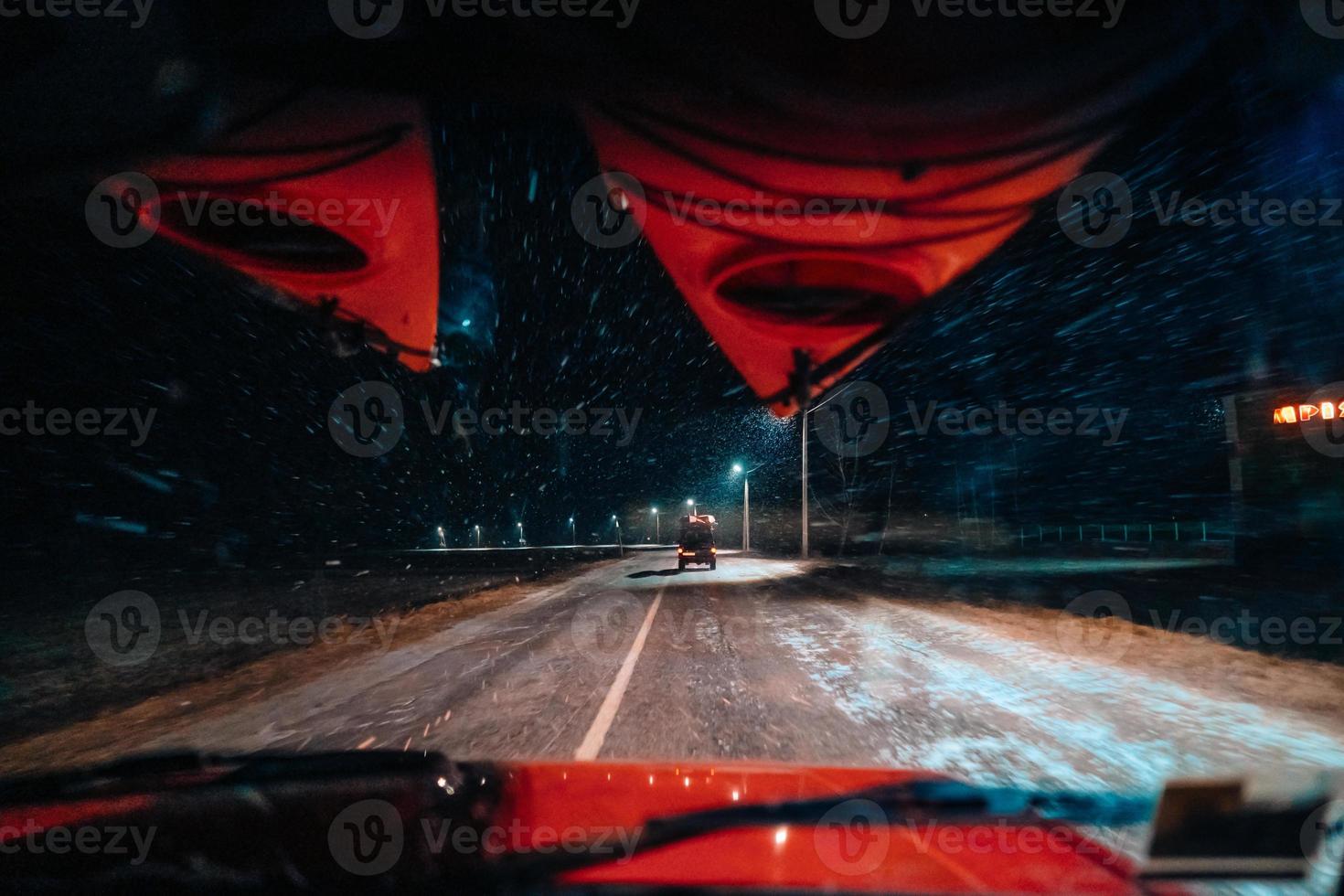 In car view of snowfall storm on the countryside road photo