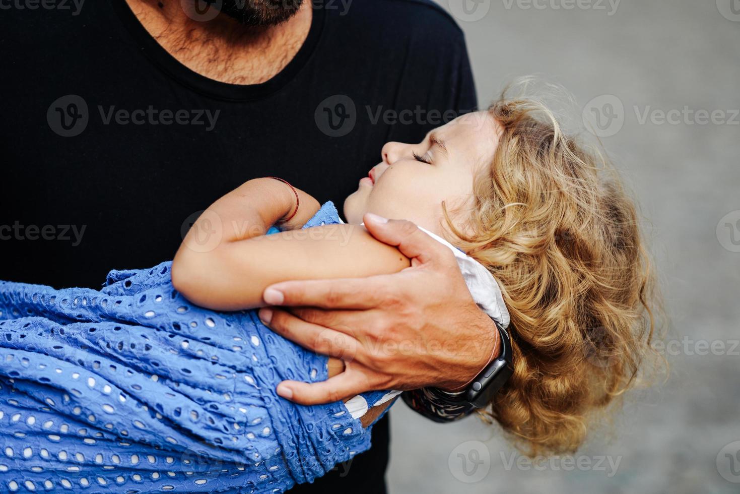 Cute little girl's sleeping in her father's arm photo