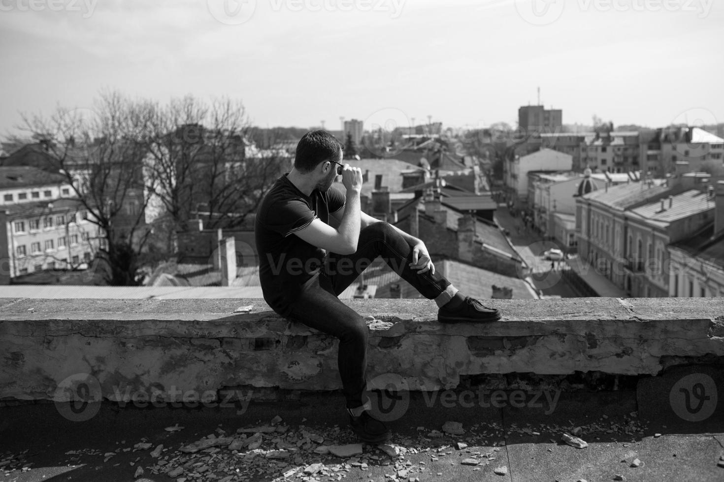 The man in the authentic boots and jeans selvedge on the roof of the building in the old town photo