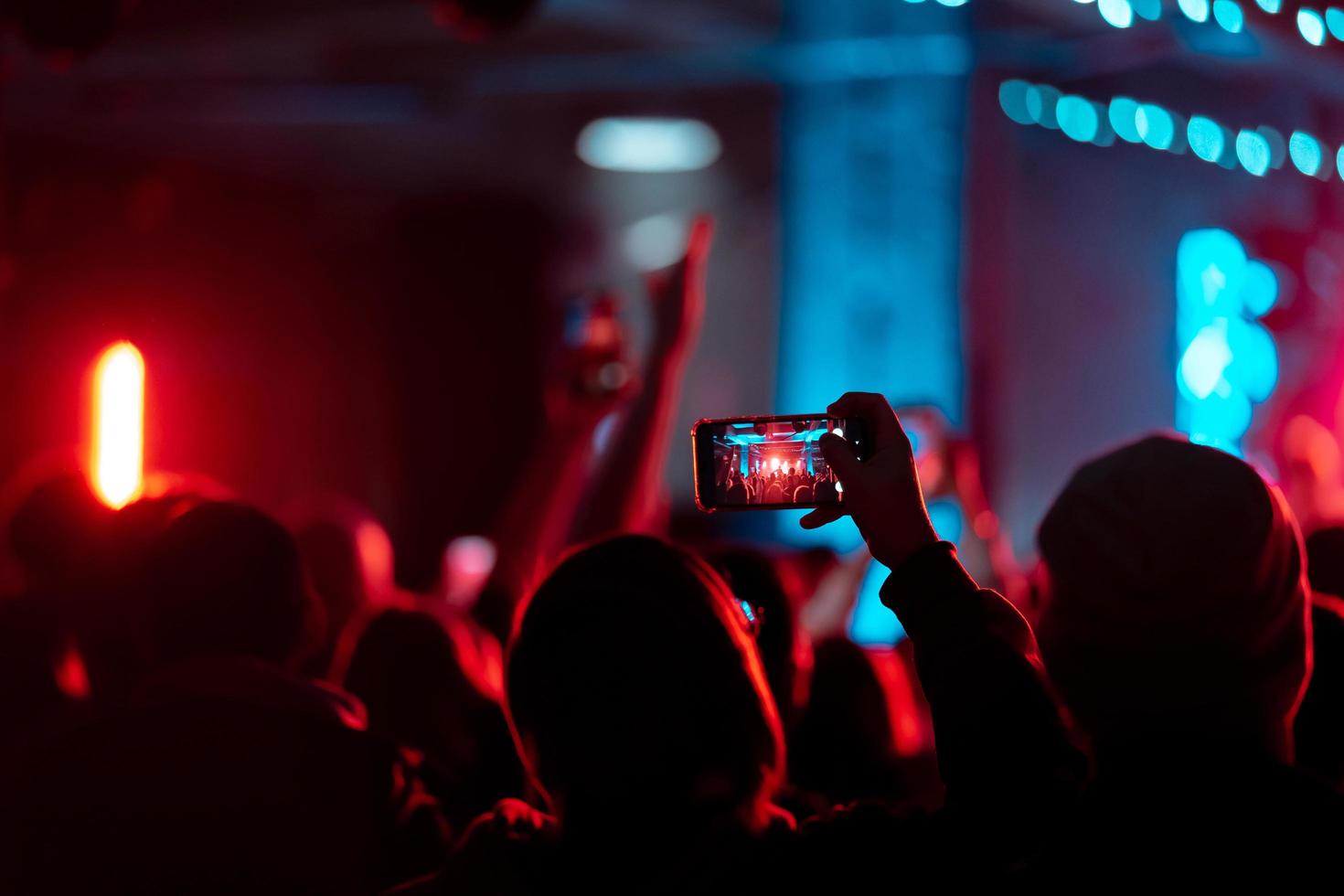 Person close up of recording video with smartphone during a concert. photo