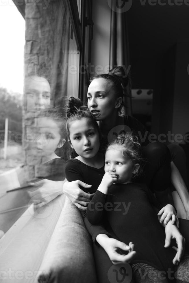 mamá y dos hijas juntas en la ventana foto