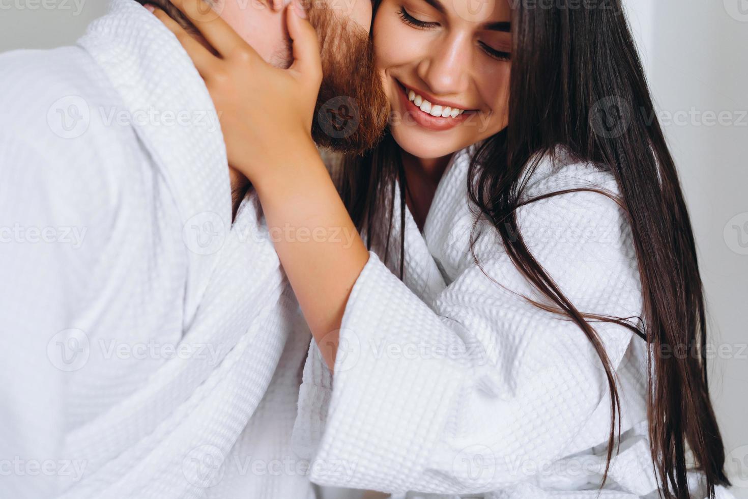 Handsome man kissing beautiful woman on cheek while photo