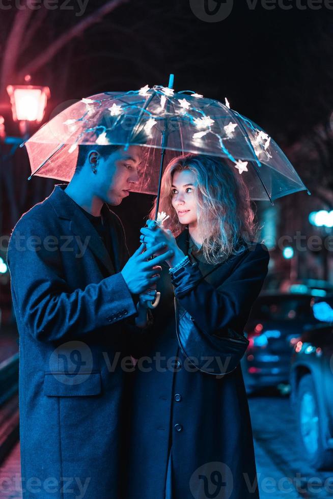 retrato de un chico y una chica bajo un paraguas foto