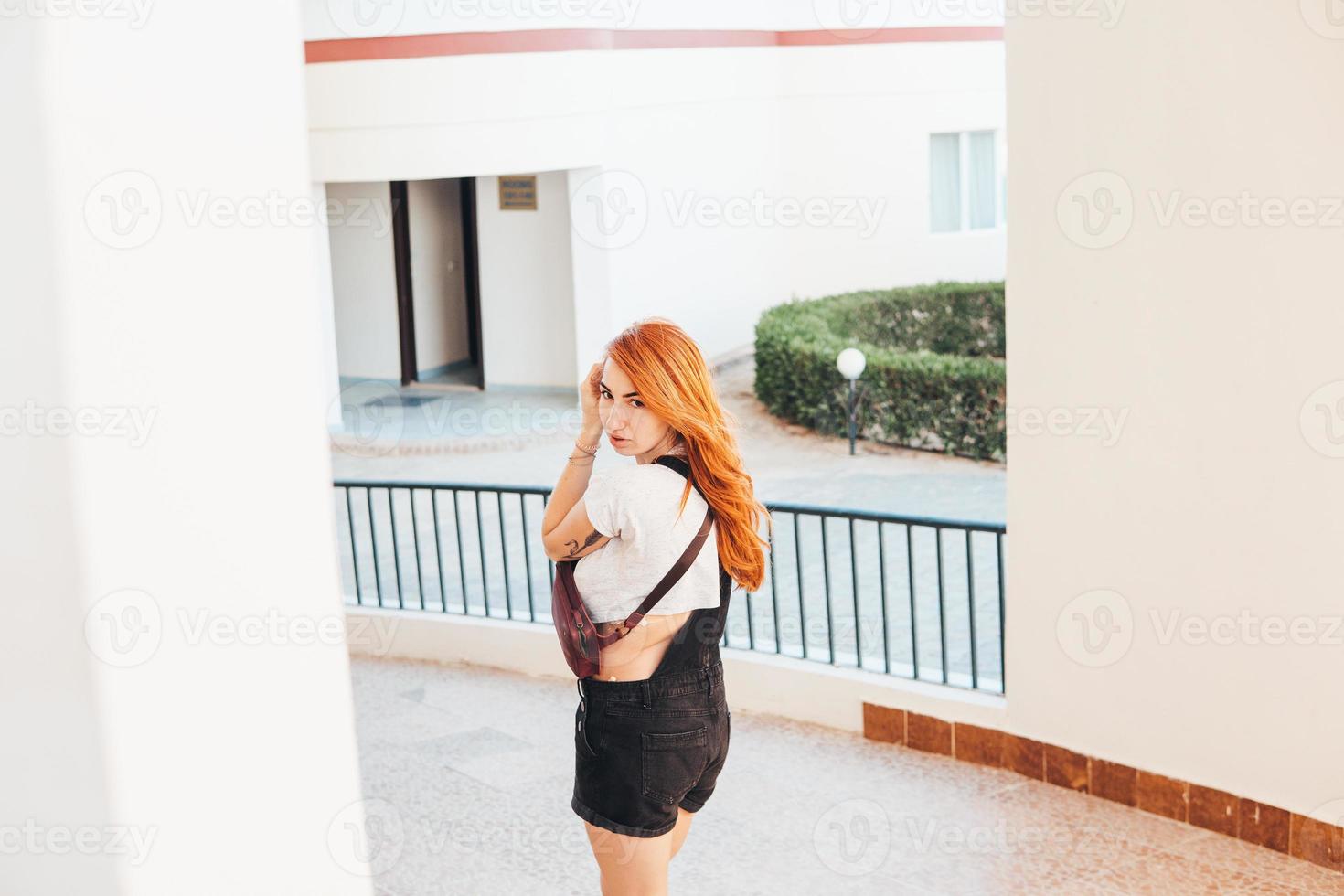 Woman with long red hair standing alongside photo